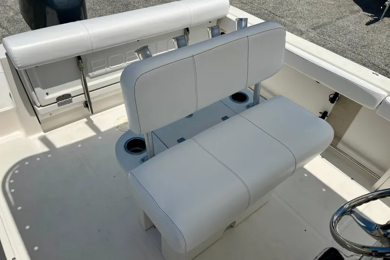 Slide: The Image of 2016 Robalo R222 Center Console boat interior with white seating and cup holders. - 12