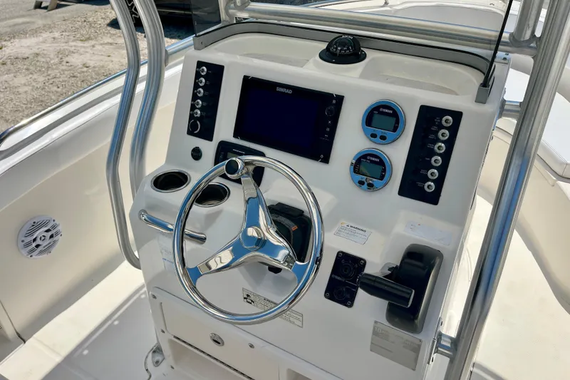 Slide: The Image of 2016 Robalo R222 Center Console boat dashboard with steering wheel and navigation controls. - 9