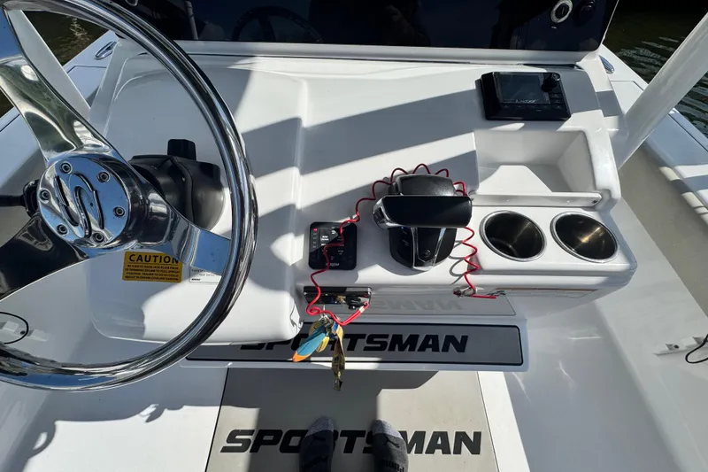 Slide: The Image of 2021 Sportsman Masters 267 Bay Boat helm with steering wheel, controls, and cup holders. - 11