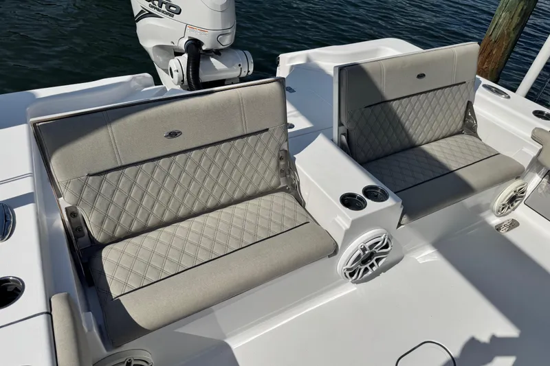 Slide: The Image of 2021 Sportsman Masters 267 Bay Boat with cushioned seating and cup holders on deck. - 27
