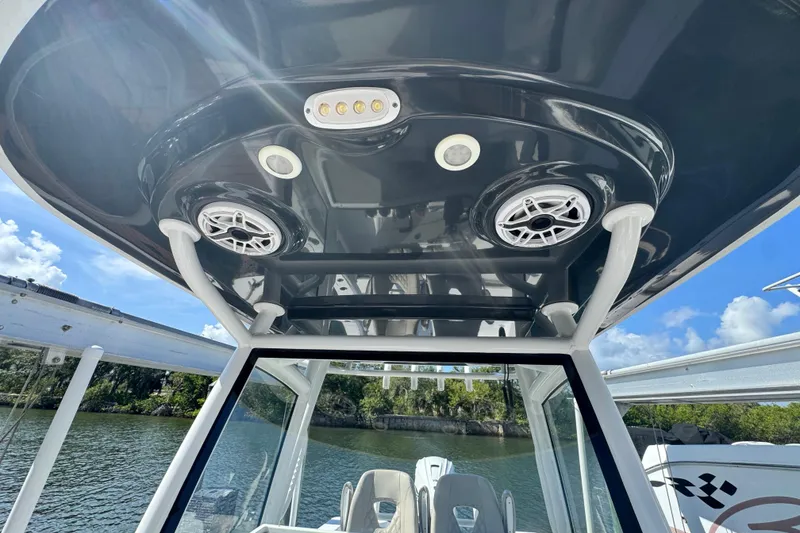 Slide: The Image of 2021 Sportsman Masters 267 Bay Boat T-top with speakers and lights, on a sunny day. - 42