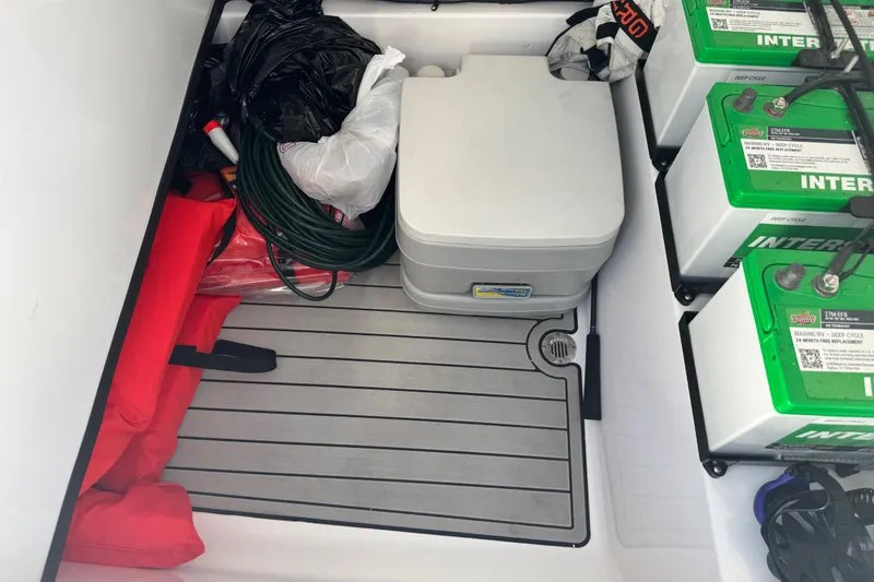 Slide: The Image of Storage compartment of a 2021 Sportsman Masters 267 Bay Boat with batteries and equipment. - 44