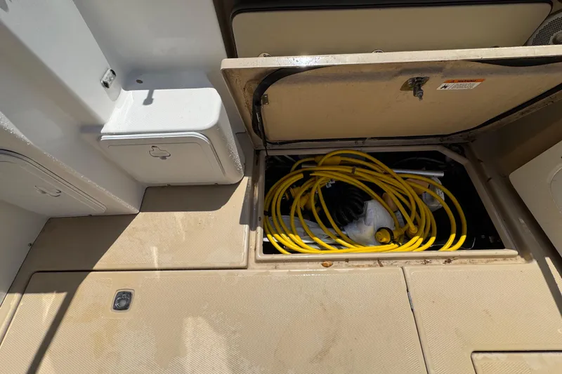 Slide: The Image of Storage compartment on 2019 Ranger Tugs R-29 CB boat with coiled yellow hose. - 12