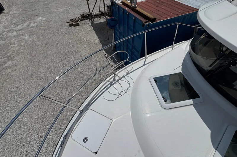 Slide: The Image of 2019 Ranger Tugs R-29 CB boat deck with railing and hatch, docked near containers. - 49