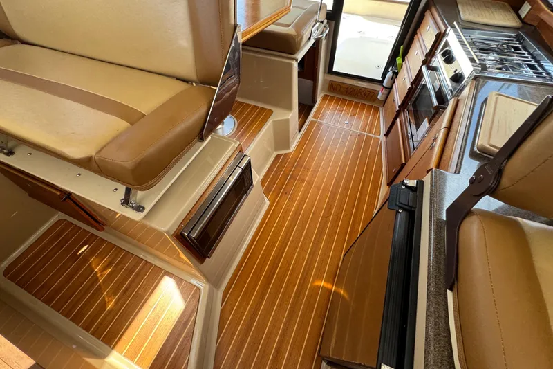 Slide: The Image of Interior of 2019 Ranger Tugs R-29 CB with wood flooring and compact kitchen area. - 36