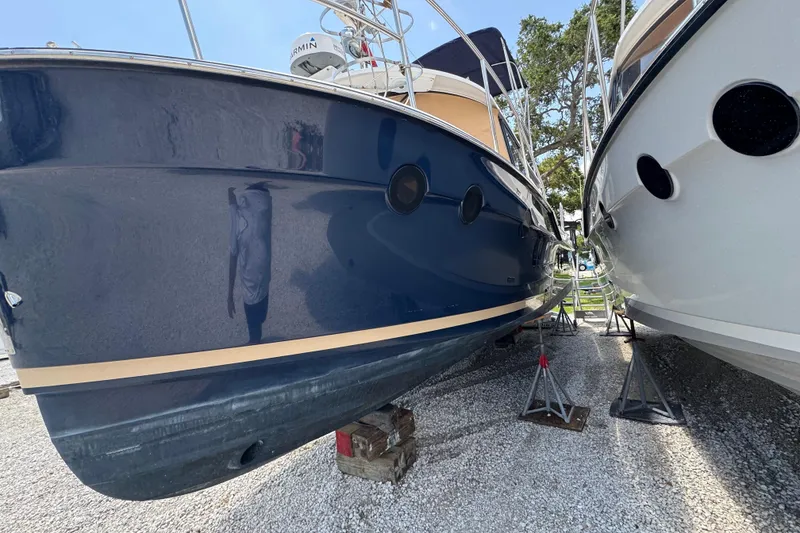 Slide: The Image of 2019 Ranger Tugs R-29 CB boat on stands, side view, blue hull. - 2