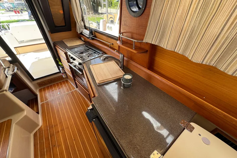 Slide: The Image of 2019 Ranger Tugs R-29 CB interior kitchen with wood finish and modern appliances. - 38