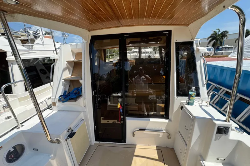 Slide: The Image of 2019 Ranger Tugs R-29 CB boat cockpit with wooden ceiling and glass door. - 6