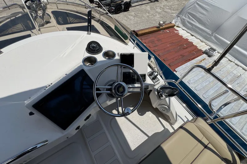 Slide: The Image of Cockpit of 2019 Ranger Tugs R-29 CB with steering wheel and navigation controls. - 44