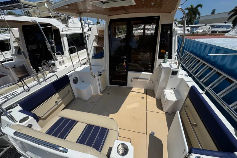 Slide: The Image of 2019 Ranger Tugs R-29 CB boat interior with seating and storage, docked in a marina. - 8