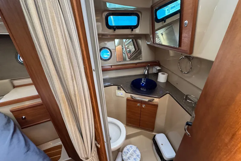 Slide: The Image of 2019 Ranger Tugs R-29 CB bathroom with sink, toilet, and wood cabinetry. - 34