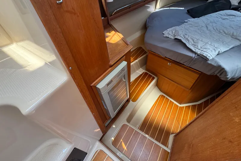 Slide: The Image of 2019 Ranger Tugs R-29 CB cabin interior with wooden flooring and cozy bed. - 29