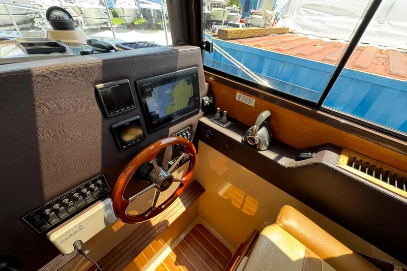 Slide: The Image of 2019 Ranger Tugs R-29 CB helm with navigation screens and wooden steering wheel. - 27