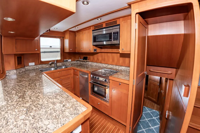 Slide: The Image of Kitchen with granite countertops and wooden cabinets in a DeFever Euro 52 yacht. - 46