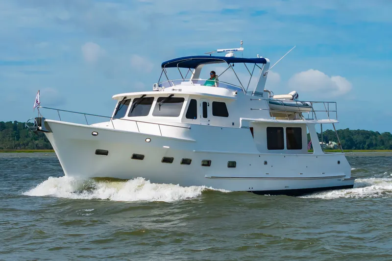 Slide: The Image of 2016 DeFever Euro 52 on the water, featuring a blue canopy and spacious deck. - 6