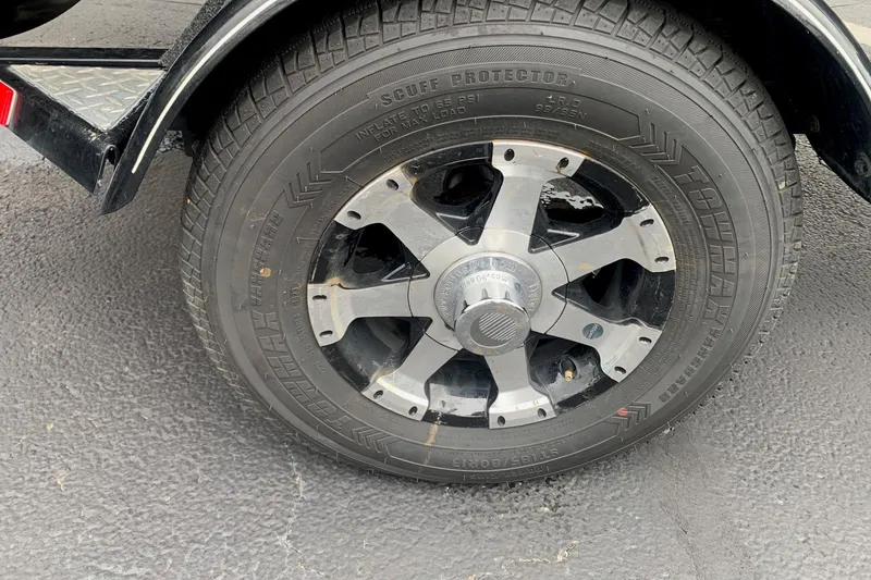 Slide: The Image of 2016 Tracker Pro Team 175 TXW trailer wheel with Towmax tire on asphalt. - 7