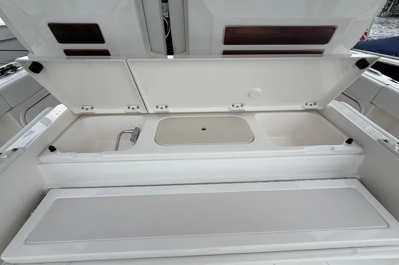 Slide: The Image of 2024 Pursuit S 328 Sport boat with open storage compartments. - 14