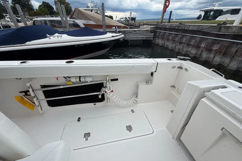 Slide: The Image of 2024 Pursuit S 328 Sport boat interior at dock, featuring storage and equipment. - 16