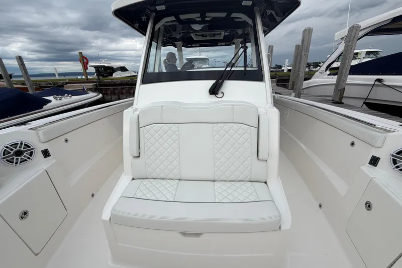 Slide: The Image of 2024 Pursuit S 328 Sport boat interior with white cushioned seating and sleek design. - 24
