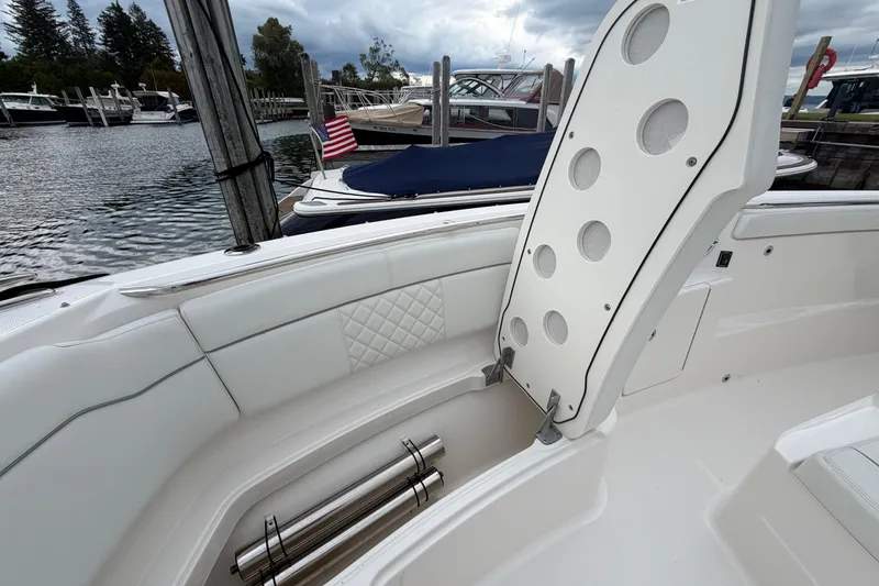 Slide: The Image of 2024 Pursuit S 328 Sport boat interior with open storage compartment, docked at marina. - 27
