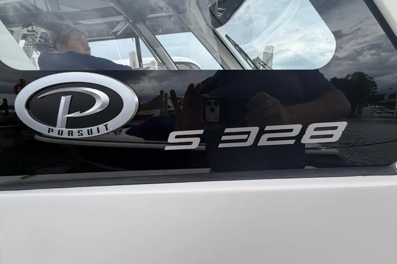Slide: The Image of 2024 Pursuit S 328 Sport boat logo and model name on reflective surface. - 28