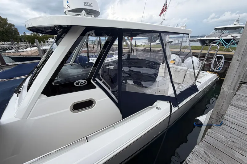 Slide: The Image of 2024 Pursuit S 328 Sport boat docked, featuring sleek design and modern amenities. - 31