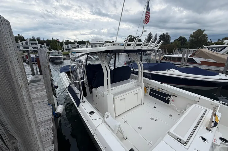 Slide: The Image of 2024 Pursuit S 328 Sport boat docked at a marina under cloudy skies. - 32