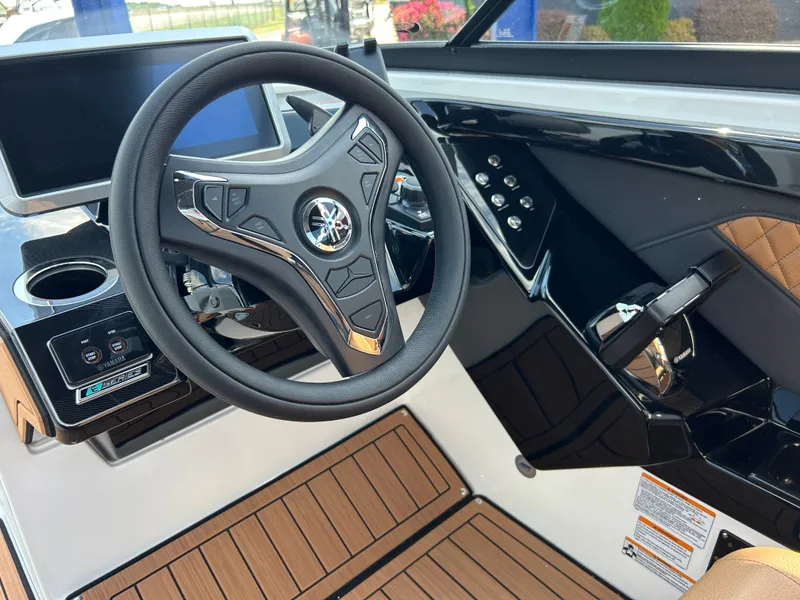 Slide: The Image of The image shows the cockpit of a Yamaha 252SD boat with a modern steering wheel and wood flooring. - 16