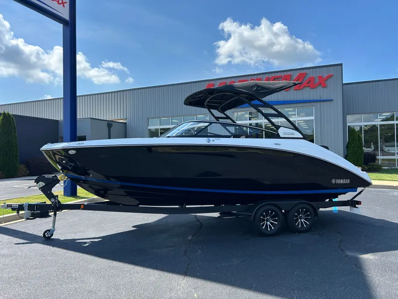 Slide: The Image of A sleek 2026 Yamaha 252SD boat on a trailer in front of a modern building. - 1