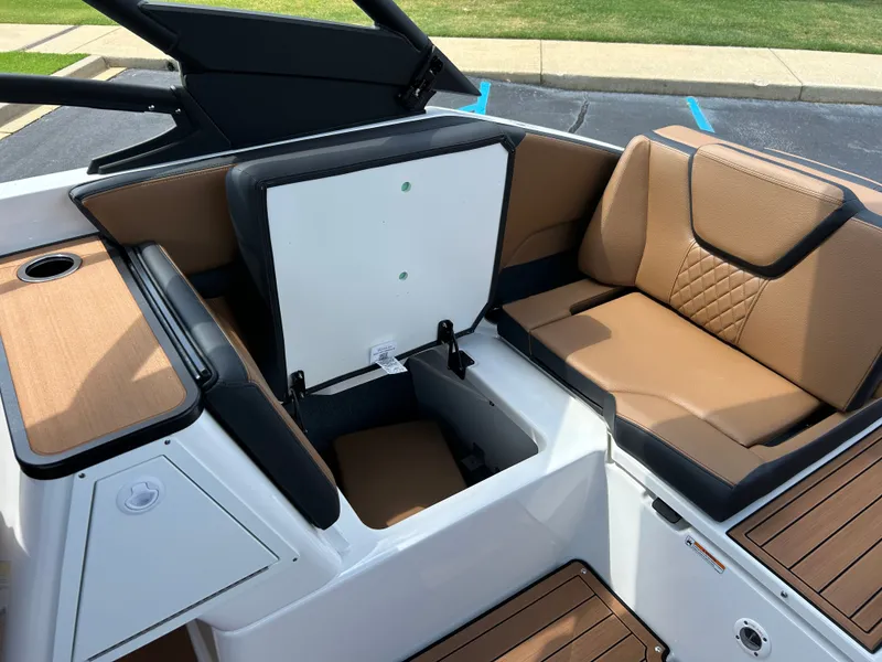 Slide: The Image of The image shows the interior of a Yamaha 252SD boat with brown seating and storage space. - 27