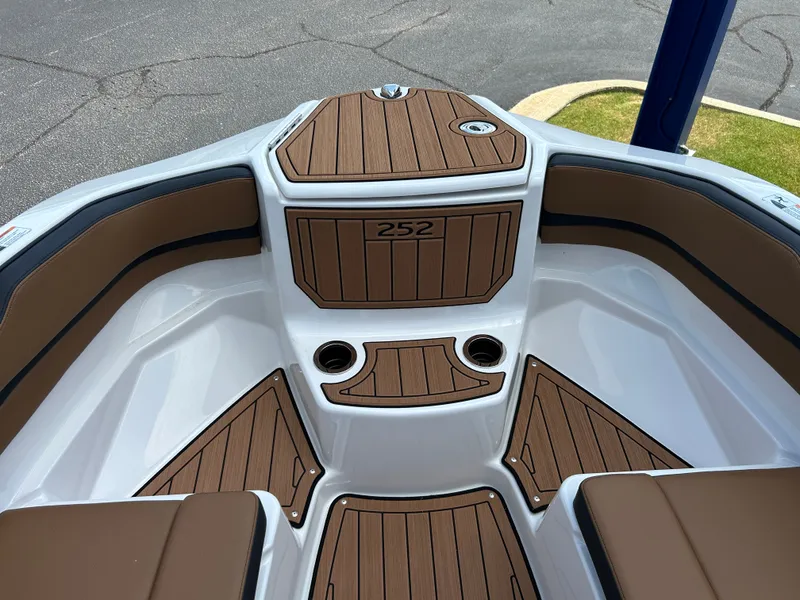 Slide: The Image of The image shows the bow area of a Yamaha 252SD boat with brown cushions and wood flooring. - 25