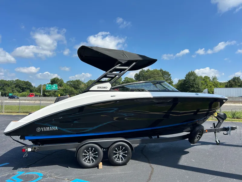 Slide: The Image of A 2026 Yamaha 252SD boat on a trailer in a parking lot under a blue sky. - 3