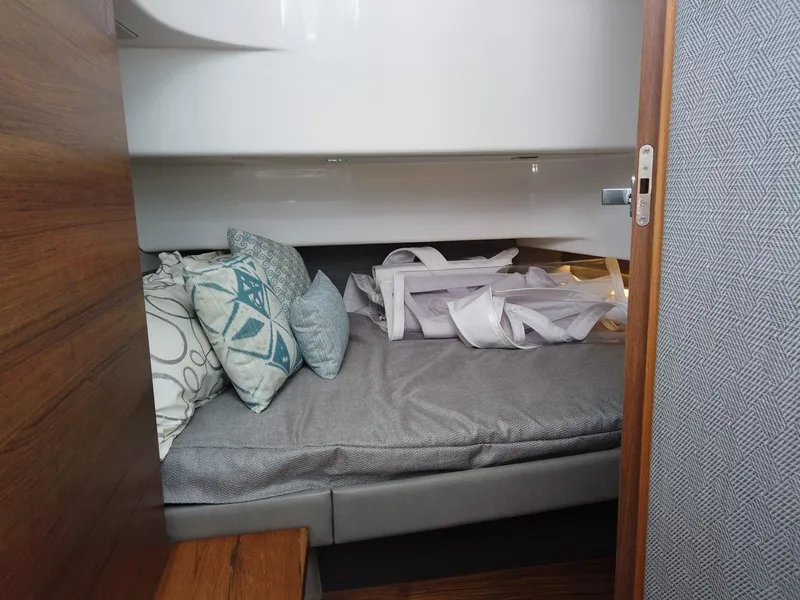 Slide: The Image of Interior of the 2024 Tiara Sport 34LS with a cozy bed and cushions. - 17