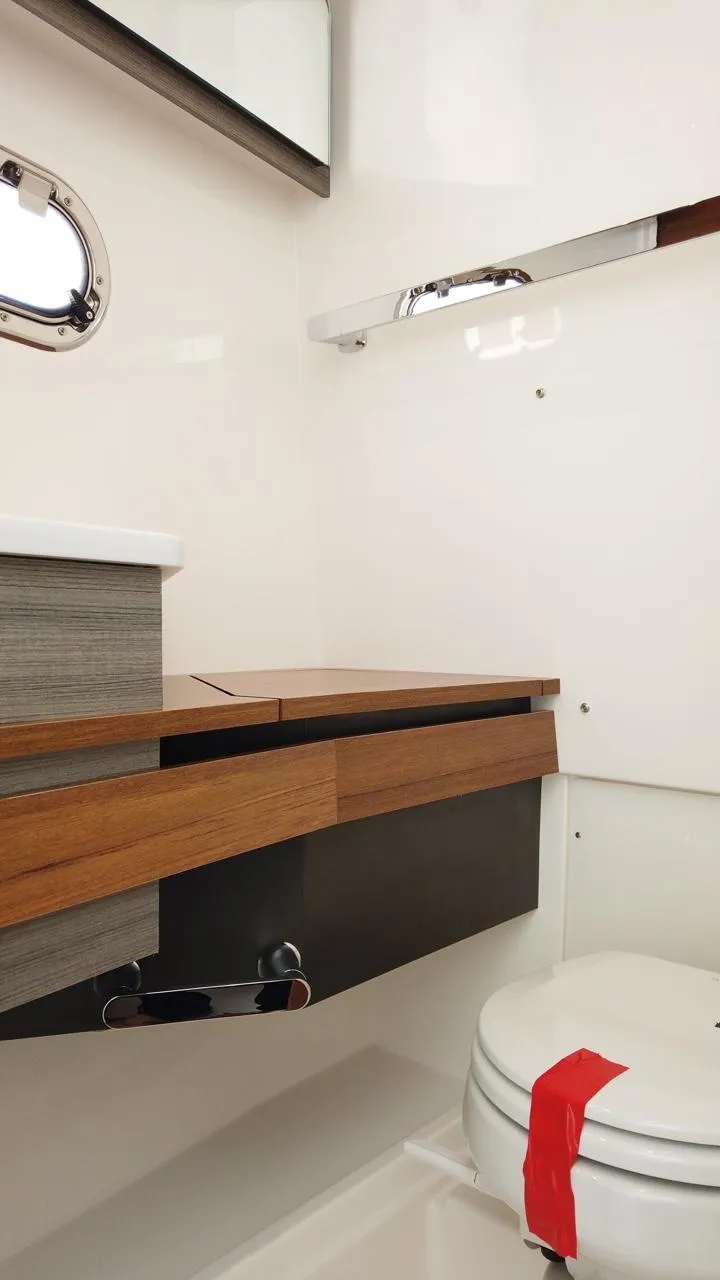 Slide: The Image of Interior view of a modern boat bathroom with wood paneling and a porthole. - 22