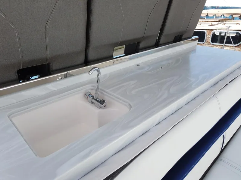 Slide: The Image of The 2024 Tiara Sport 34LS features a sleek outdoor kitchen with a sink and faucet. - 3