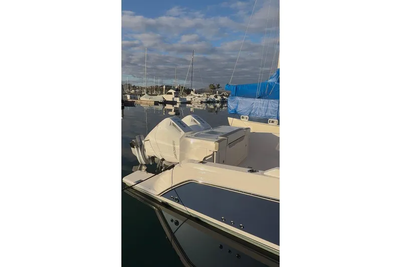 Slide: The Image of 2024 Tiara Sport 34LS boat docked in a marina under a cloudy sky. - 30