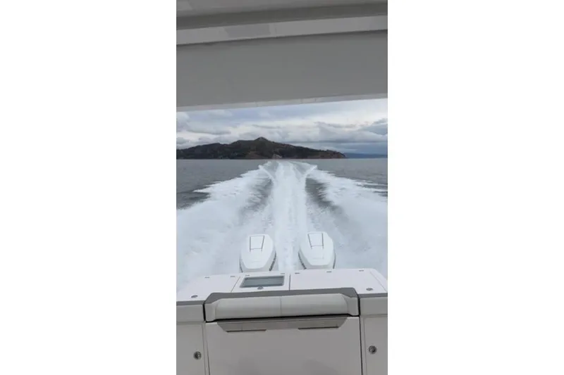 Slide: The Image of 2024 Tiara Sport 34LS boat cruising on open water, leaving a wake trail. - 31