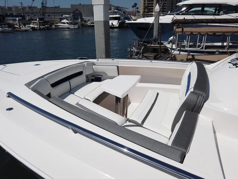 Slide: The Image of The image shows the bow of a 2024 Tiara Sport 34LS with seating area and table. - 7