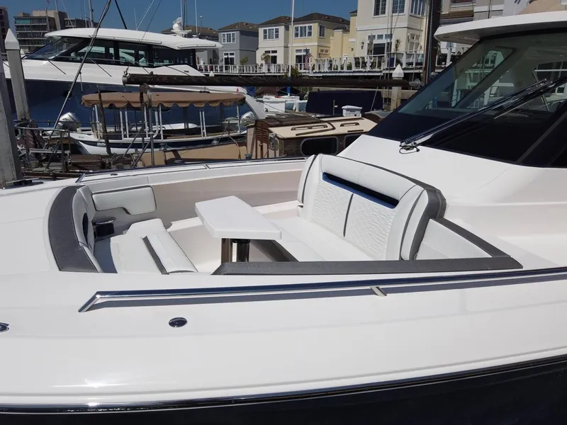 Slide: The Image of Tiara Sport 34LS 2024: Luxurious boat with elegant seating area and table at the dock. - 8