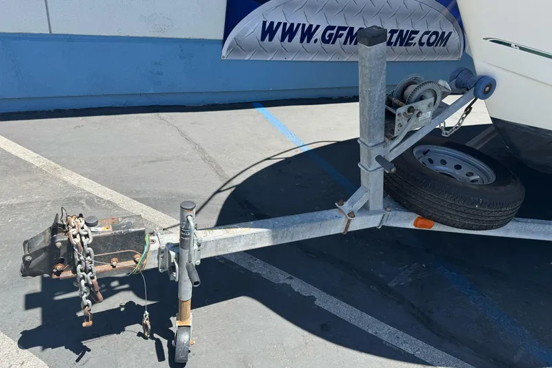 Slide: The Image of Trailer hitch and winch of a 2004 Trophy 2359 WA boat in a parking lot. - 3