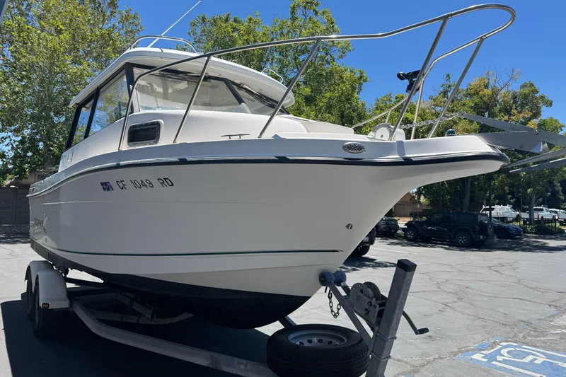 Slide: The Image of 2004 Trophy 2359 WA boat on trailer in sunny parking lot. - 4