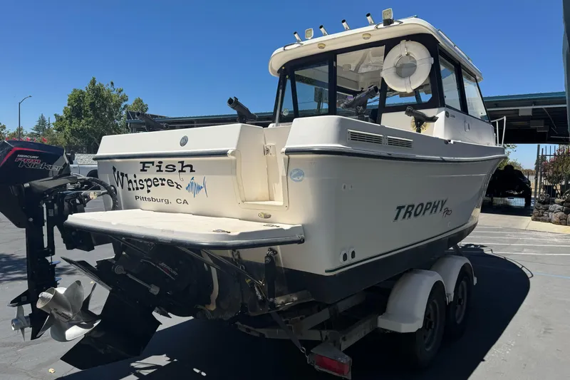 Slide: The Image of 2004 Trophy 2359 WA boat on trailer, labeled "Fish Whisperer," parked outdoors in Pittsburg, CA. - 6