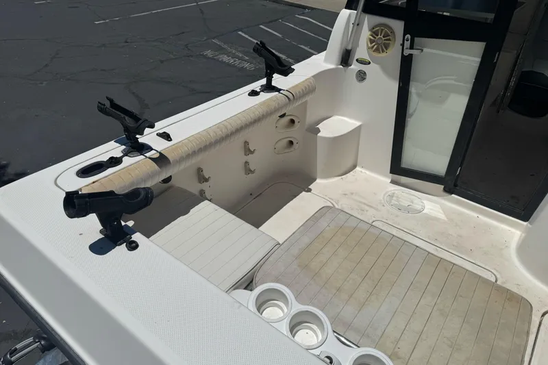 Slide: The Image of 2004 Trophy 2359 WA boat interior with rod holders and seating area. - 9
