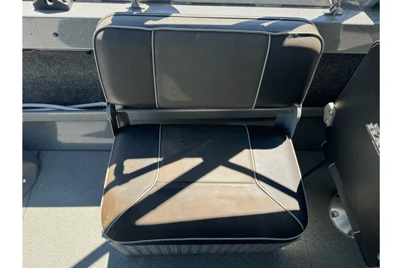 Slide: The Image of Black seat in a 2014 River Hawk 19 GB boat, sunlight casting shadows. - 17