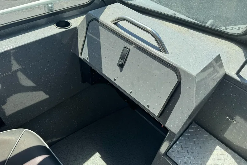 Slide: The Image of Interior of a 2014 River Hawk 19 GB boat, featuring a glove compartment and seating area. - 22