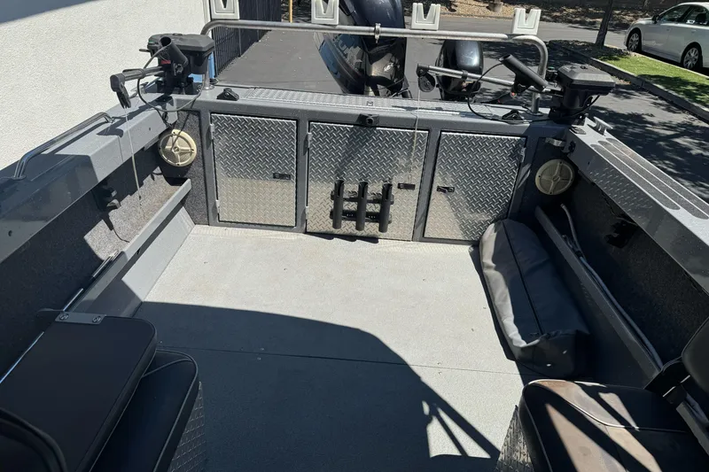 Slide: The Image of Interior of a 2014 River Hawk 19 GB boat with storage compartments and seating. - 25
