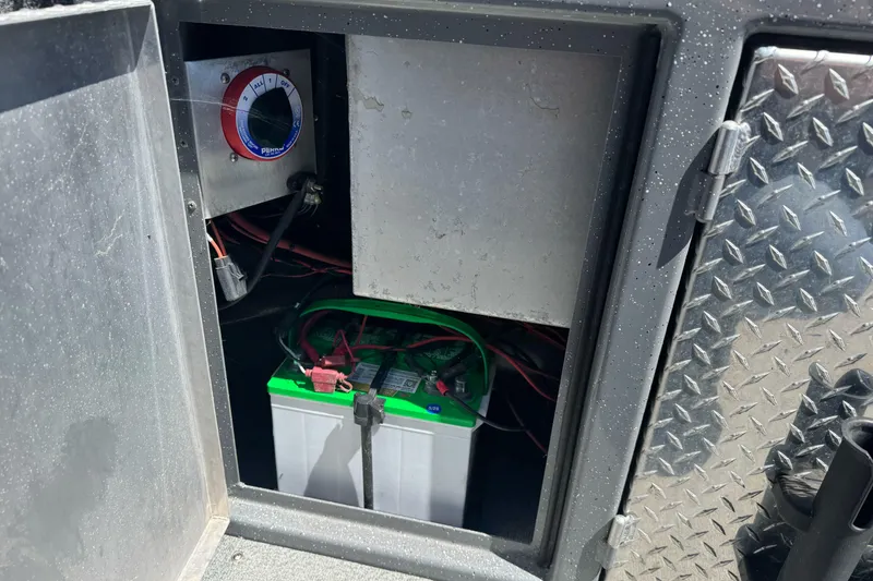 Slide: The Image of Battery compartment of a 2014 River Hawk 19 GB boat with wiring and control panel. - 26