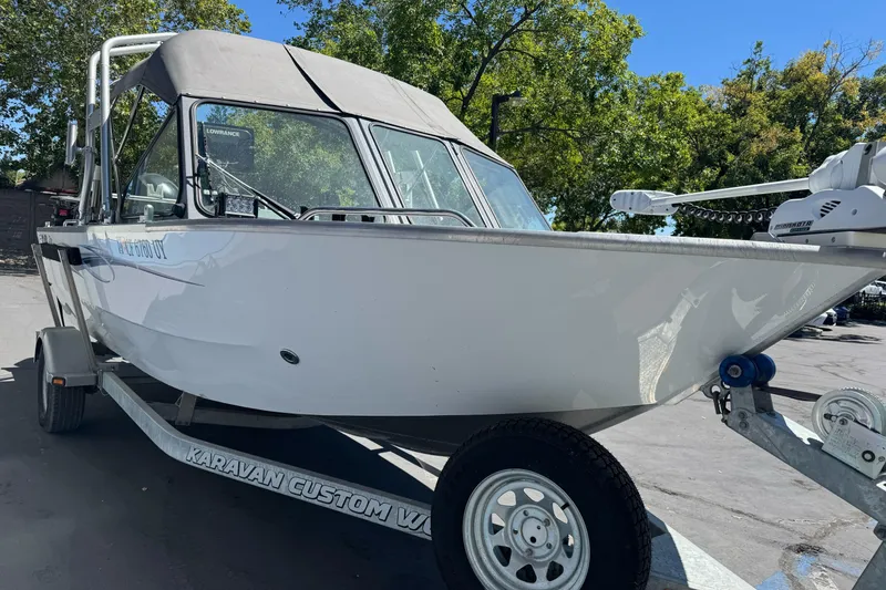 Slide: The Image of 2014 River Hawk 19 GB boat on trailer, parked outdoors under clear sky. - 4