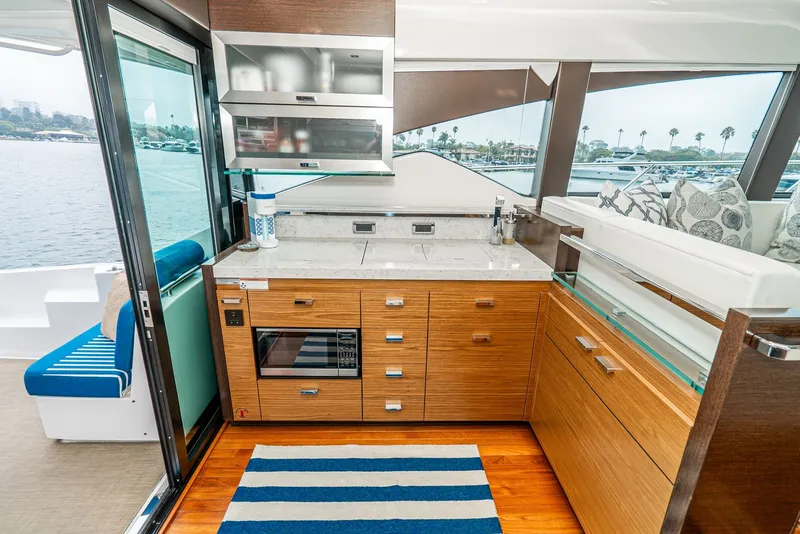 Slide: The Image of The galley of a 2017 Tiara Yachts C53 Coupe with wooden cabinets and a view of the water. - 19