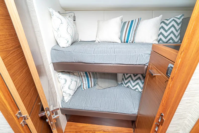 Slide: The Image of Interior of the 2017 Tiara Yachts C53 Coupe with bunk beds and decorative pillows. - 21